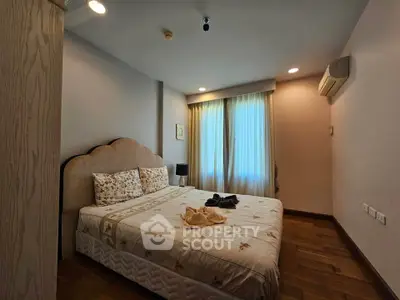Cozy bedroom with elegant decor and soft lighting, featuring a comfortable bed and wooden flooring.