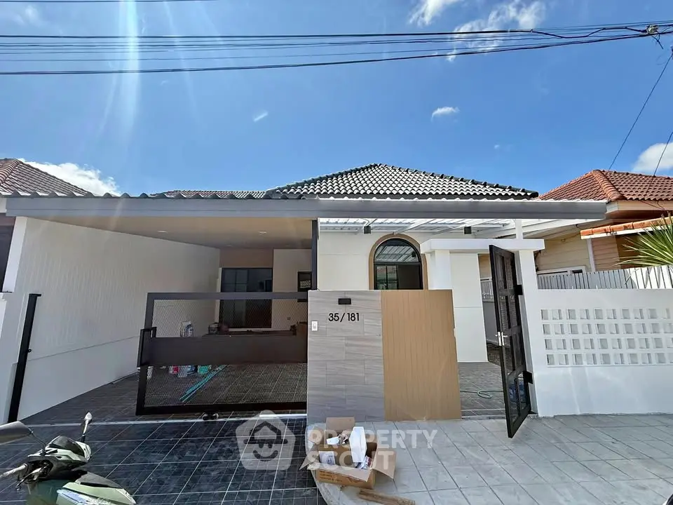 Charming single-story home with modern facade and spacious driveway in a serene neighborhood.