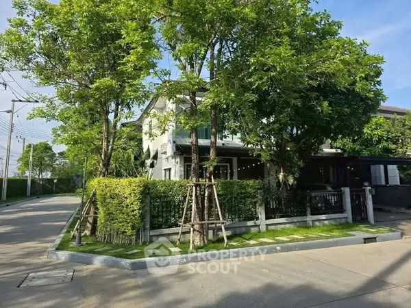 Charming suburban house with lush greenery and modern design on a sunny day.