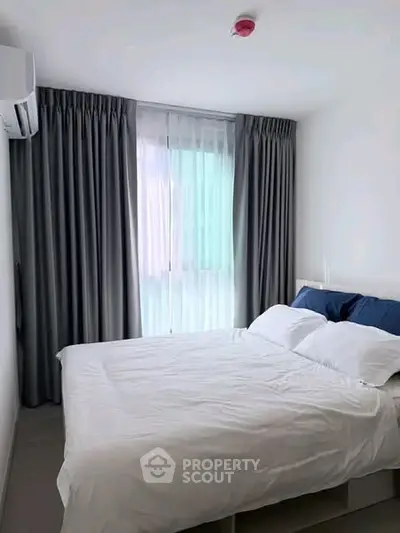 Cozy bedroom with modern decor and large window for natural light