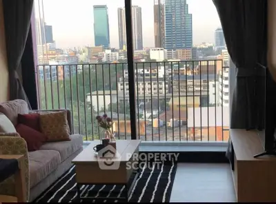 Modern living room with city view from large window, cozy seating, and stylish decor.