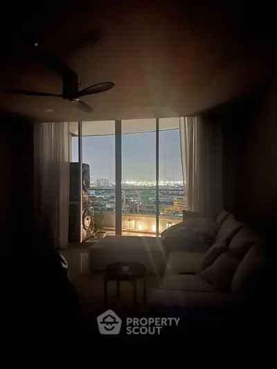 Cozy living room with stunning city view through large windows, perfect for relaxation and entertainment.