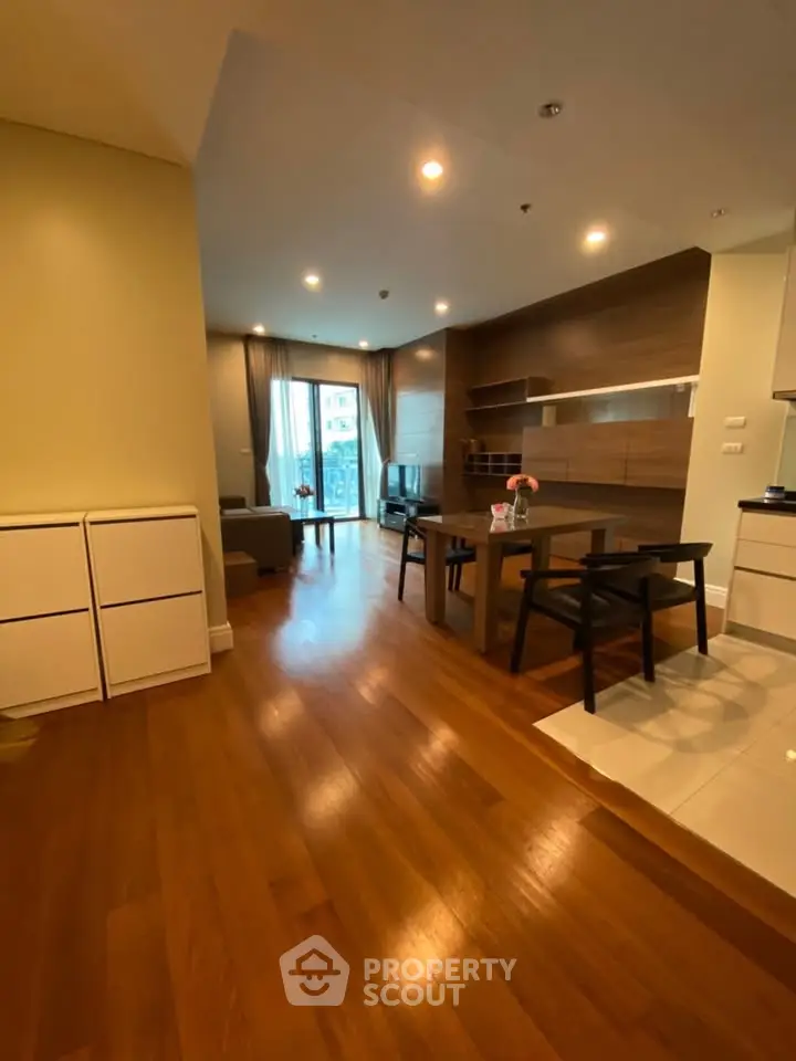 Spacious modern living room with wooden flooring and stylish furniture in a cozy apartment.
