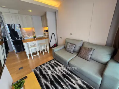 Modern living room with open kitchen, cozy sofa, and stylish decor in a contemporary apartment.