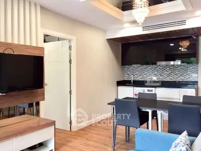 Modern living room with open kitchen, stylish decor, and elegant lighting
