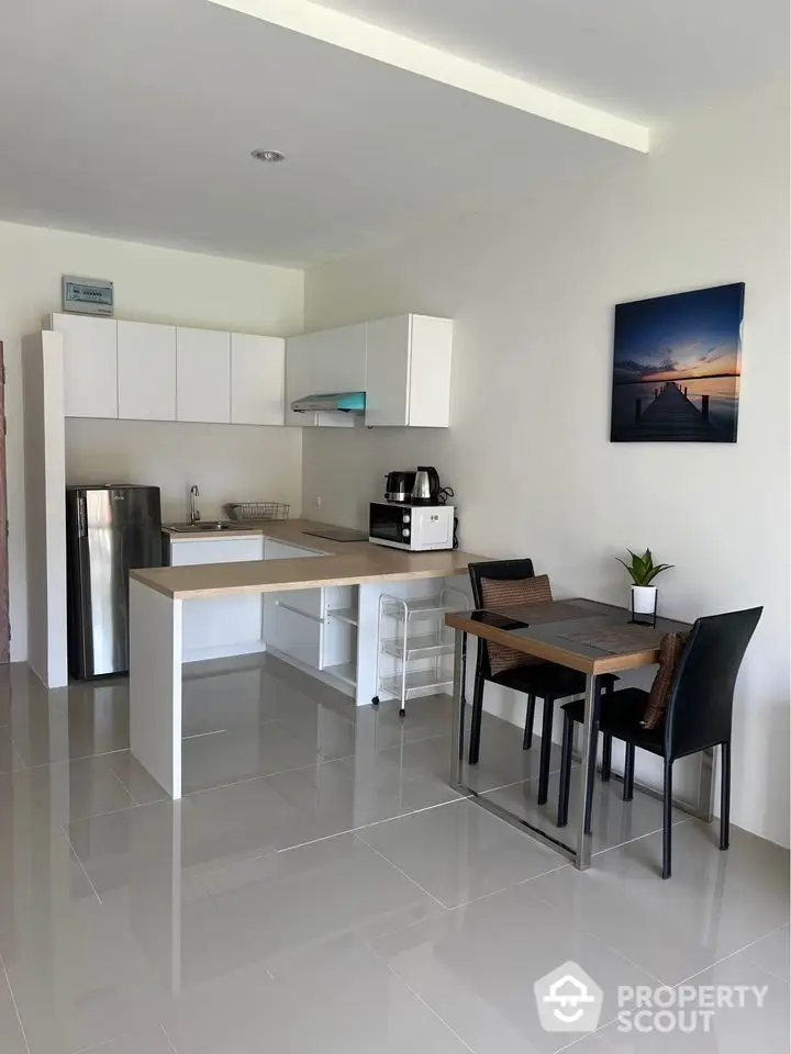 Modern kitchen with sleek design, open layout, and dining area in a stylish apartment.