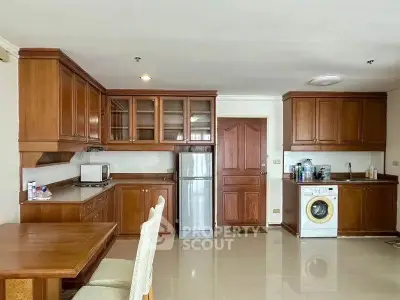 Spacious kitchen with wooden cabinets and modern appliances in a cozy apartment.