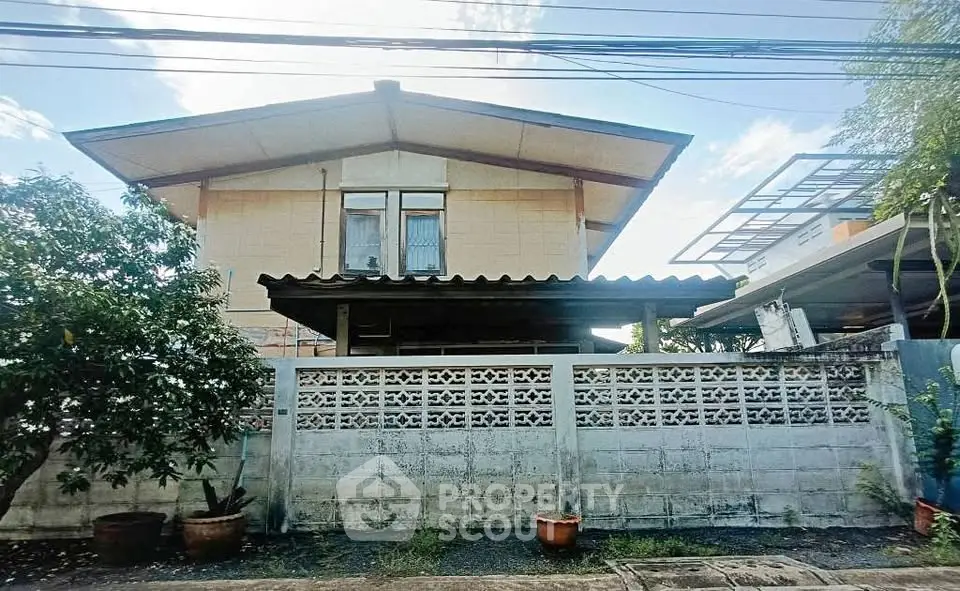 Charming two-story house with unique architectural design and lush greenery, perfect for family living.