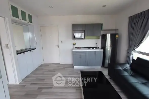 Modern living room with sleek kitchen and stylish furniture in open layout apartment.