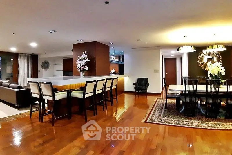 Spacious open-plan living and dining area with elegant decor and hardwood floors