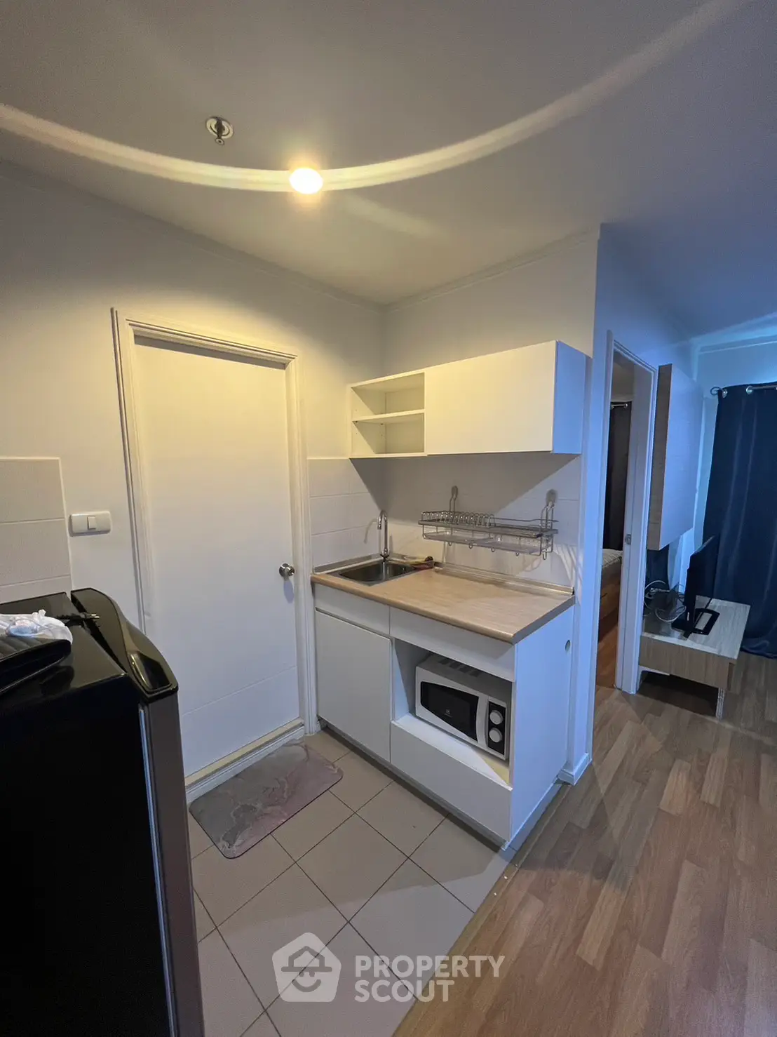 Compact kitchen with modern appliances and wooden flooring