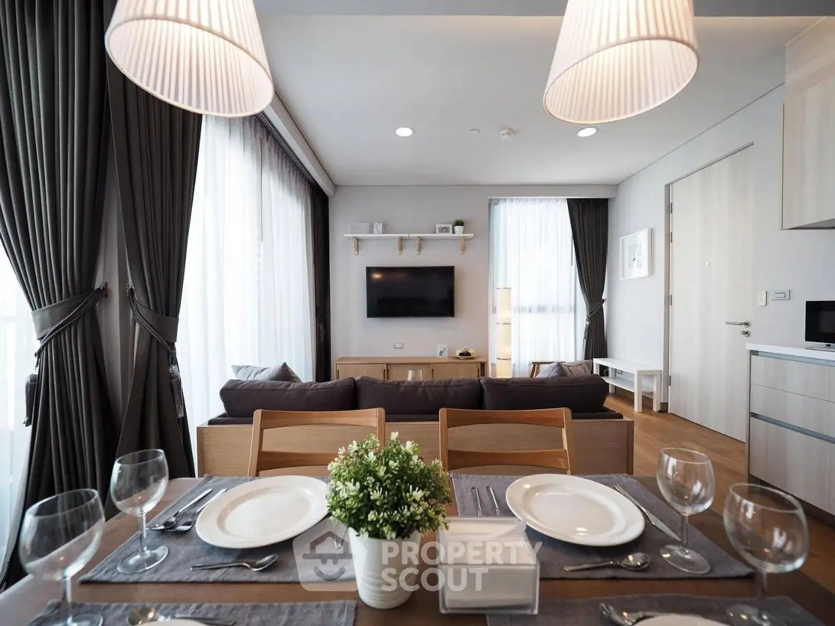 Modern living room with elegant dining setup and cozy seating area, perfect for entertaining.