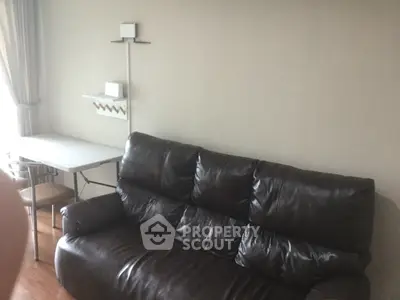 Cozy living room with leather sofa and dining table, perfect for relaxation and dining.