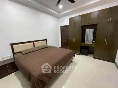Spacious bedroom with modern furnishings and ample storage in a stylish real estate property.