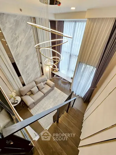 Luxurious modern living room with high ceilings and elegant spiral chandelier, perfect for sophisticated urban living.