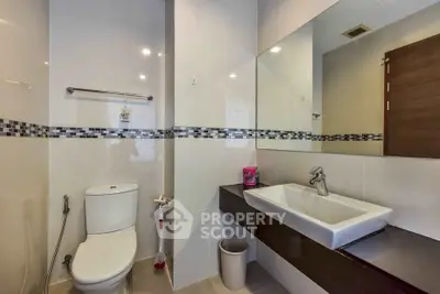 Modern bathroom with sleek fixtures and large mirror in contemporary apartment.