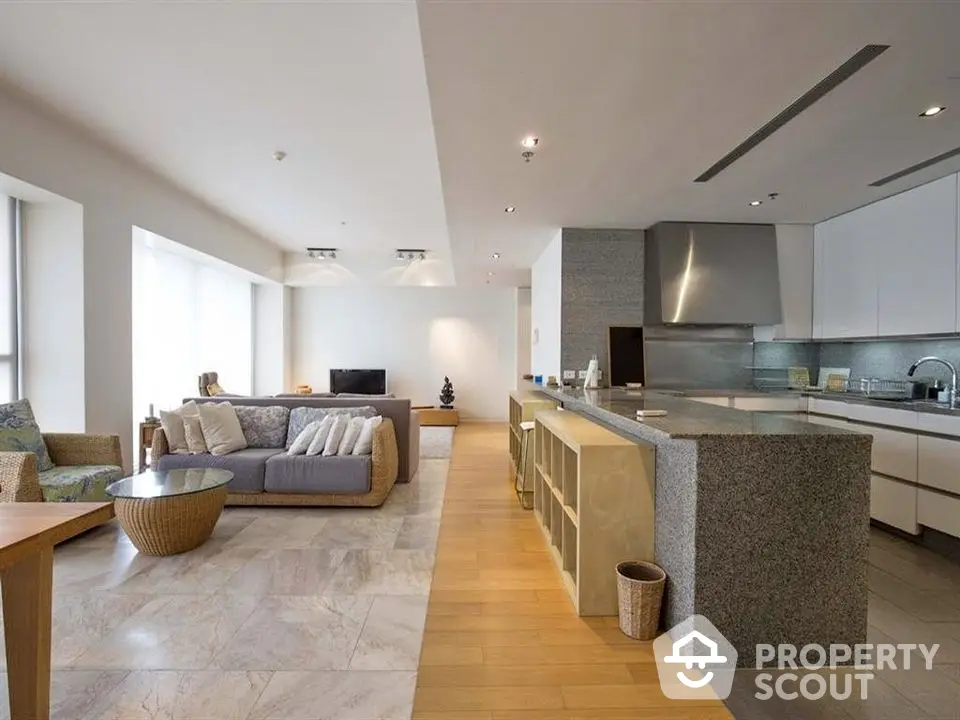 Spacious open-plan living room and kitchen with modern design and ample natural light.