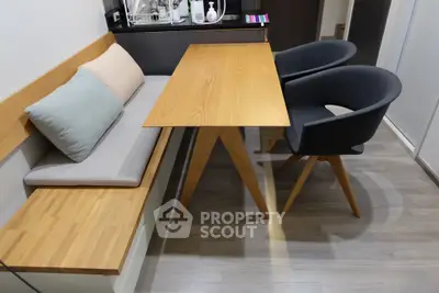 Modern dining area with wooden table and stylish chairs in cozy apartment.