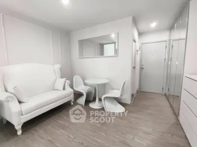 Modern minimalist living room with elegant white furniture and sleek wood flooring.