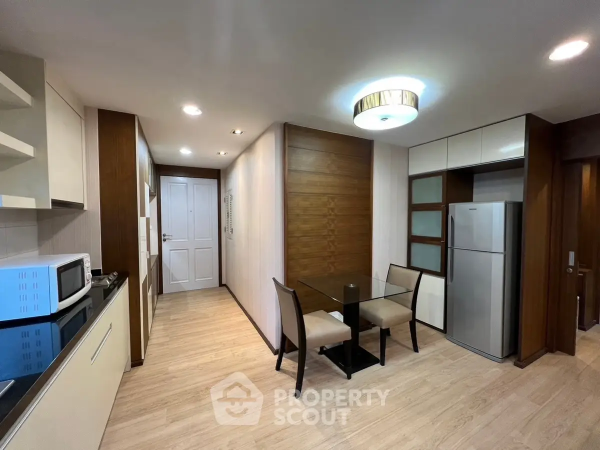 Modern kitchen with dining area featuring sleek cabinetry and stainless steel appliances.