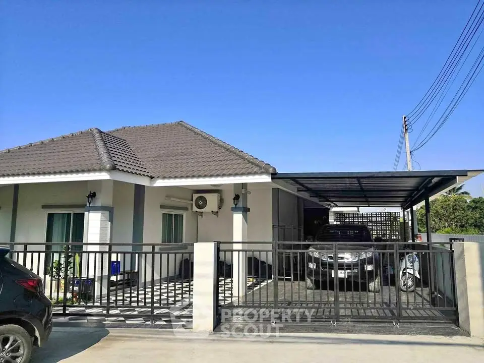 Charming single-story house with modern design, spacious driveway, and secure gated entrance.