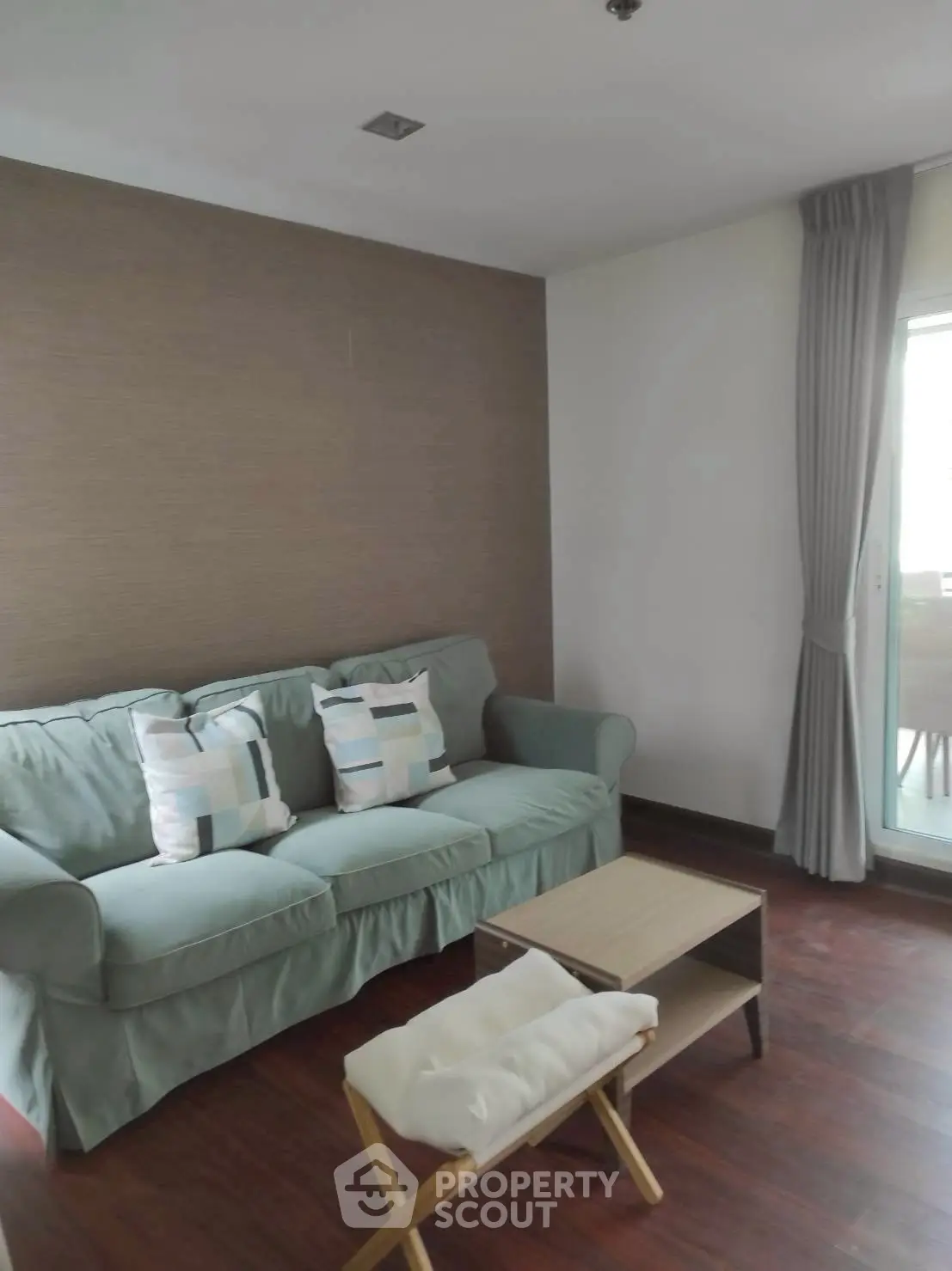 Cozy living room with stylish sofa and wooden flooring, perfect for relaxation.