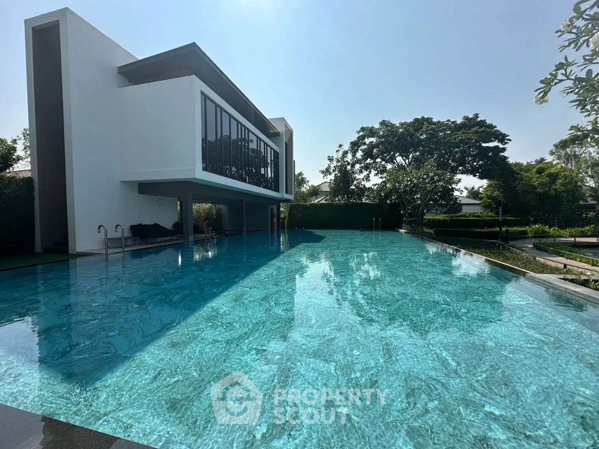 Luxurious modern building with stunning pool and lush greenery, perfect for relaxation and leisure.