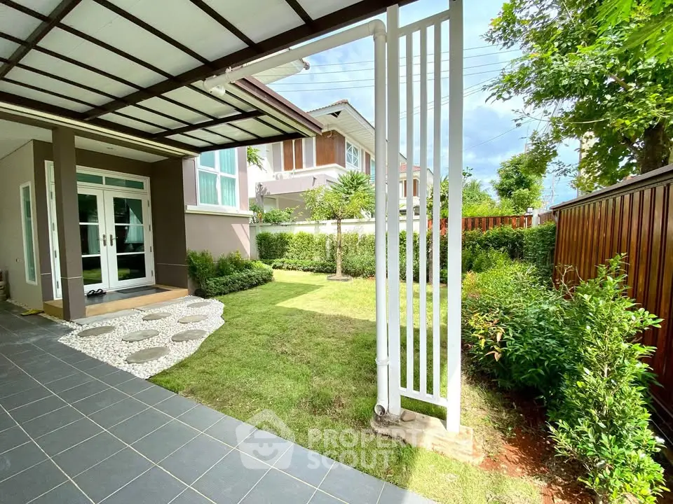 Charming garden view from a modern home with lush greenery and stylish patio.