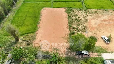 Aerial view of a vacant plot surrounded by lush greenery, ideal for development.