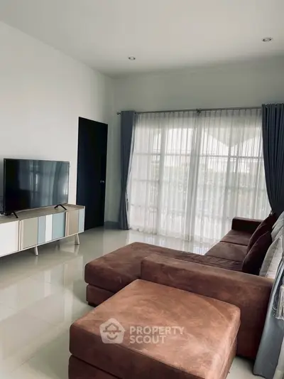 Spacious living room with modern decor and large windows for natural light.