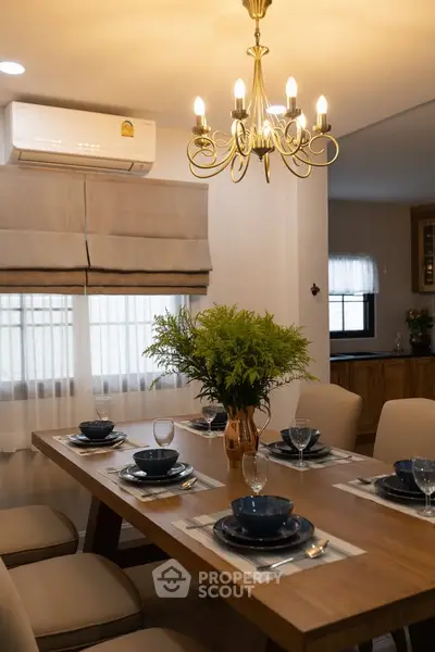 Elegant dining room with chandelier and modern table setting in a cozy home.