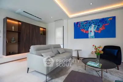 Modern living room with stylish decor and vibrant artwork, featuring a comfortable sofa and elegant lighting.