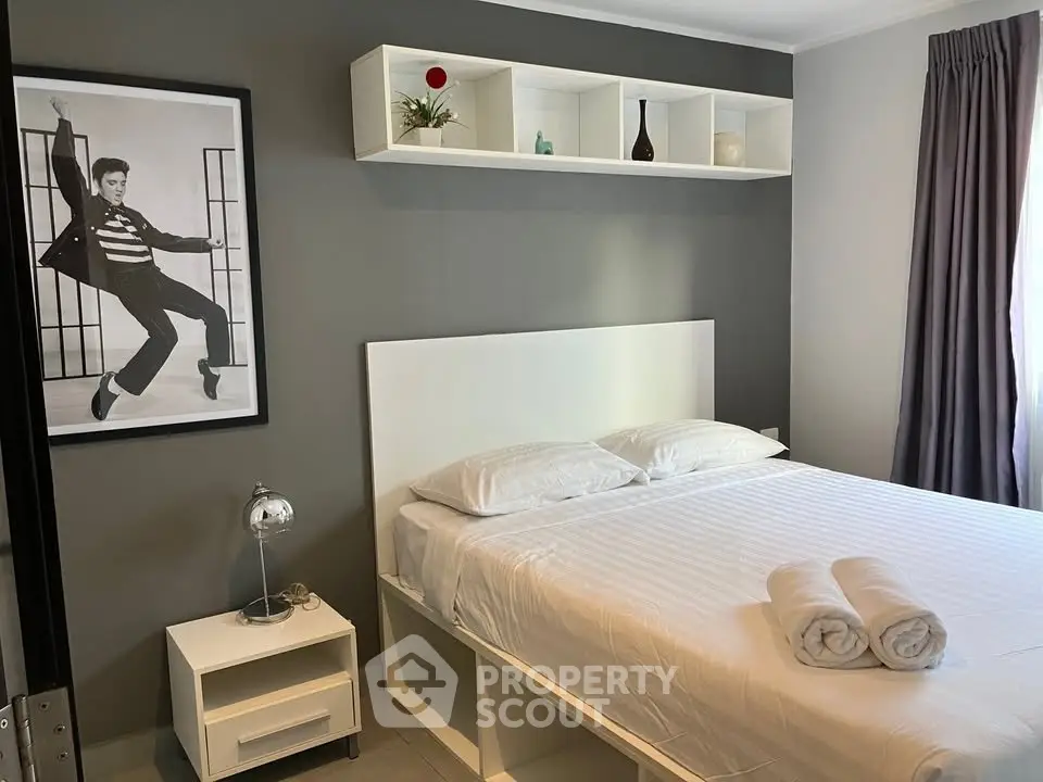 Modern bedroom with stylish decor and cozy ambiance, featuring a neatly made bed and elegant shelving.