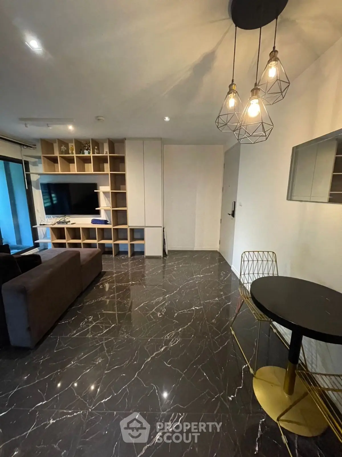 Modern living room with sleek marble flooring and stylish lighting fixtures.