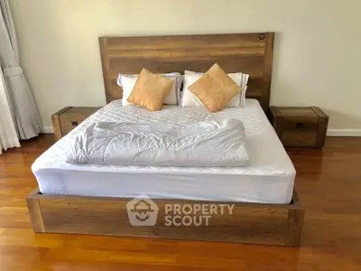 Spacious bedroom with elegant wooden bed frame and cozy decor