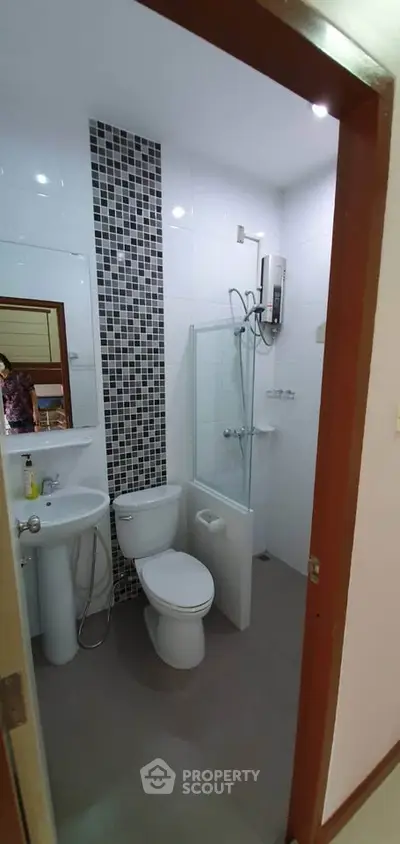Modern bathroom with sleek design and shower enclosure in a stylish apartment.