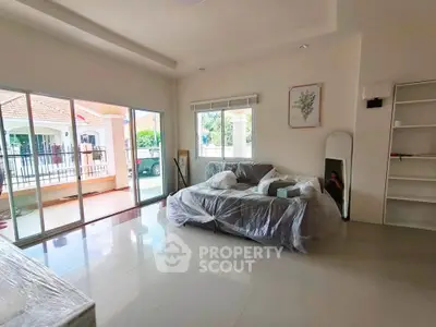 Spacious living room with large windows and modern decor in a bright home.