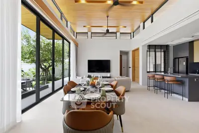 Luxurious open-plan living room with modern kitchen and garden view, featuring elegant dining area and high ceilings.