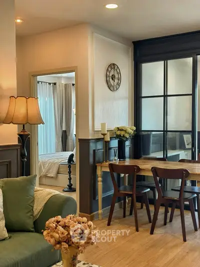 Charming living room with elegant decor and cozy dining area, featuring a glimpse into a stylish bedroom.