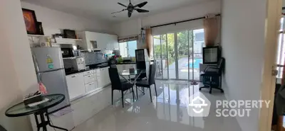 Modern open-plan kitchen and dining area with pool view