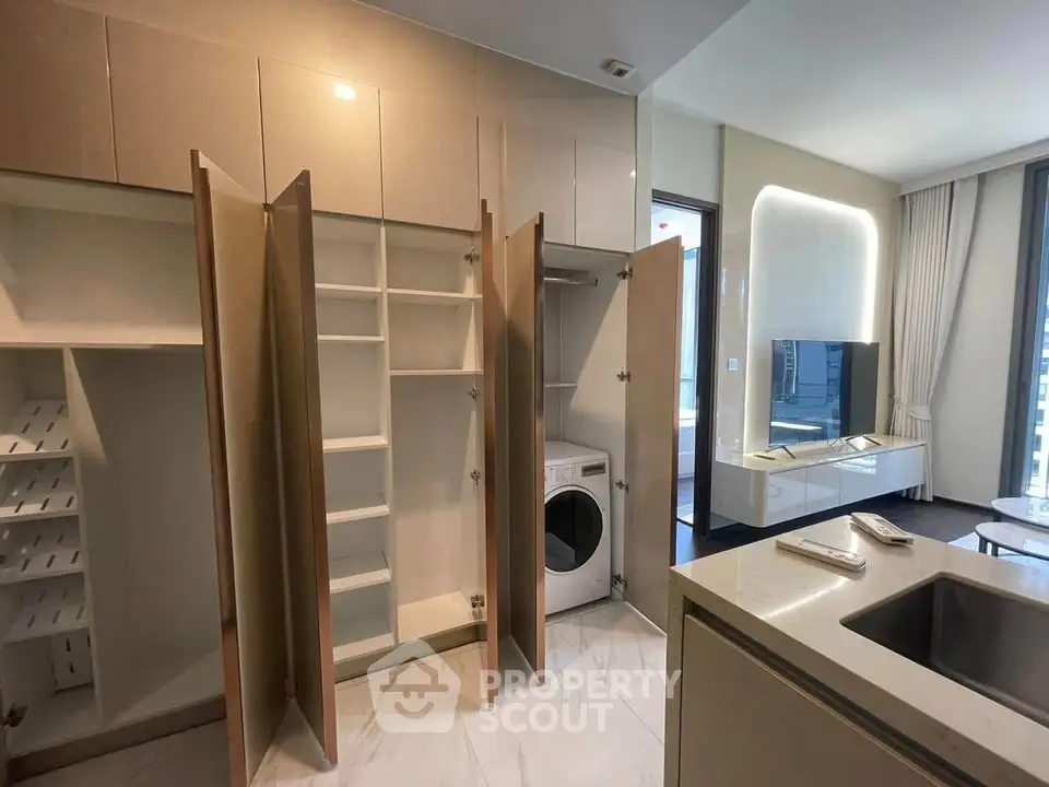 Modern apartment interior with open cabinets and washing machine