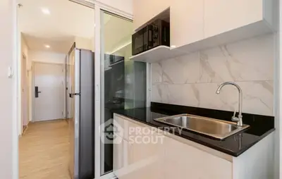 Modern kitchen with sleek cabinetry and built-in appliances in a compact layout.