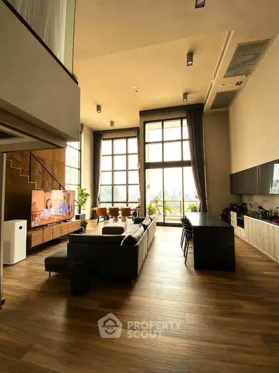Luxurious loft with high ceilings, modern kitchen, and stunning city view.