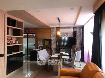 Modern living room with stylish decor and open layout, featuring a dining area and cozy seating.