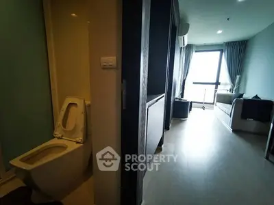 Modern apartment interior with bathroom and living area, featuring sleek design and natural light.