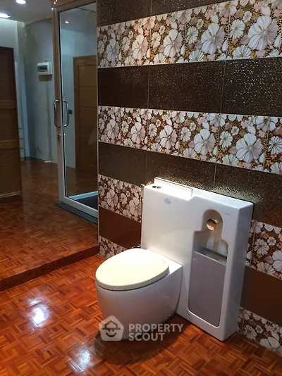Modern bathroom with unique floral tile design and sleek toilet