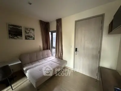 Cozy living room with modern sofa and natural light, perfect for relaxation.