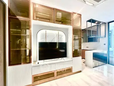 Luxurious modern living room with sleek built-in entertainment center and open kitchen layout.