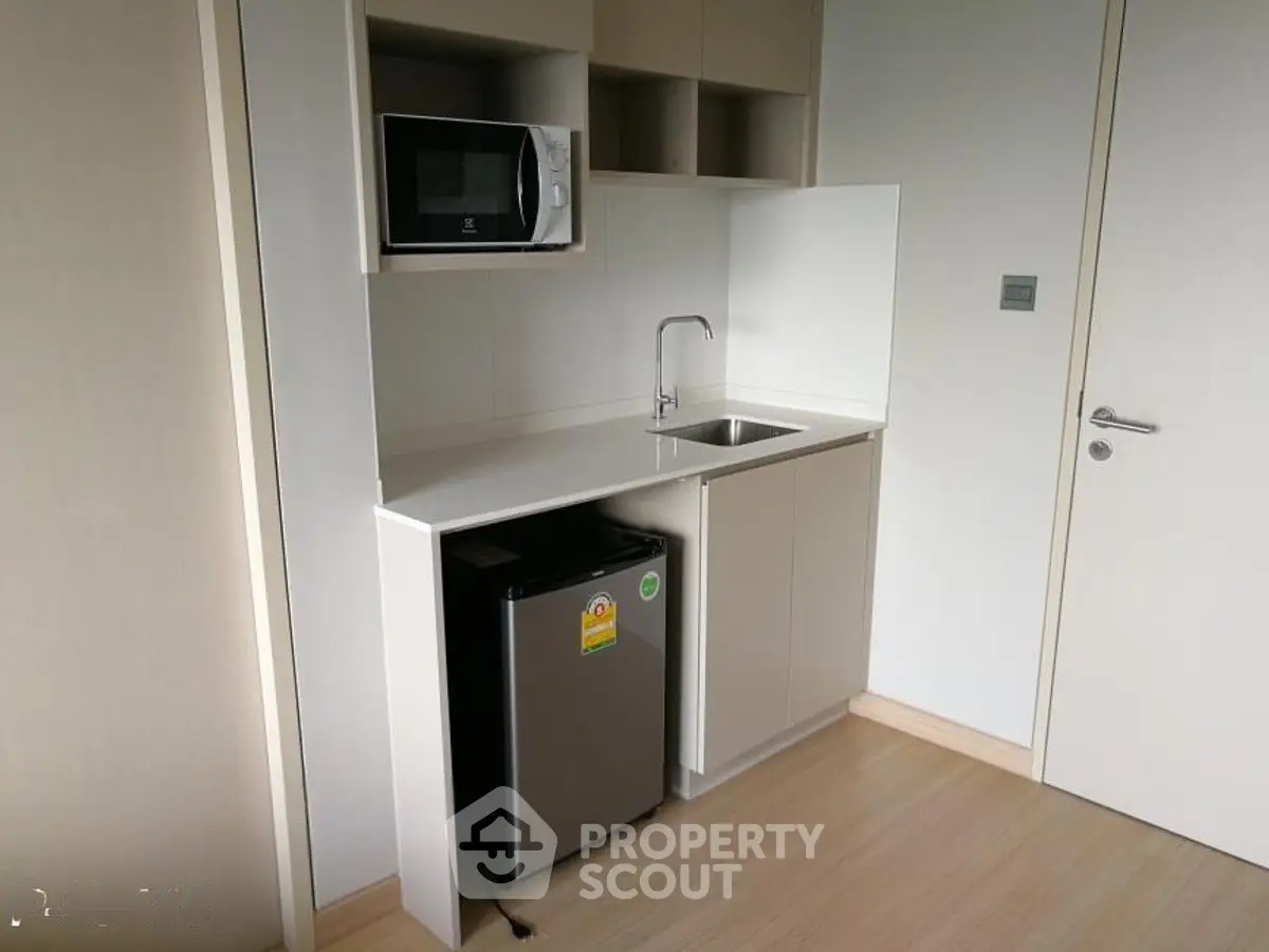 Compact modern kitchen with microwave and mini fridge in sleek apartment