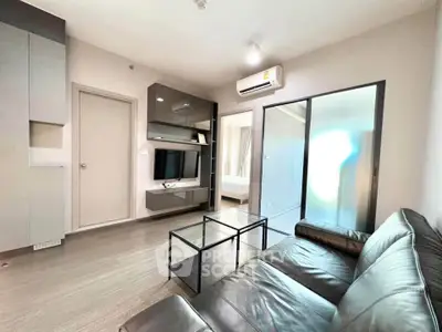 Modern living room with sleek furniture and air conditioning, leading to a bright bedroom.